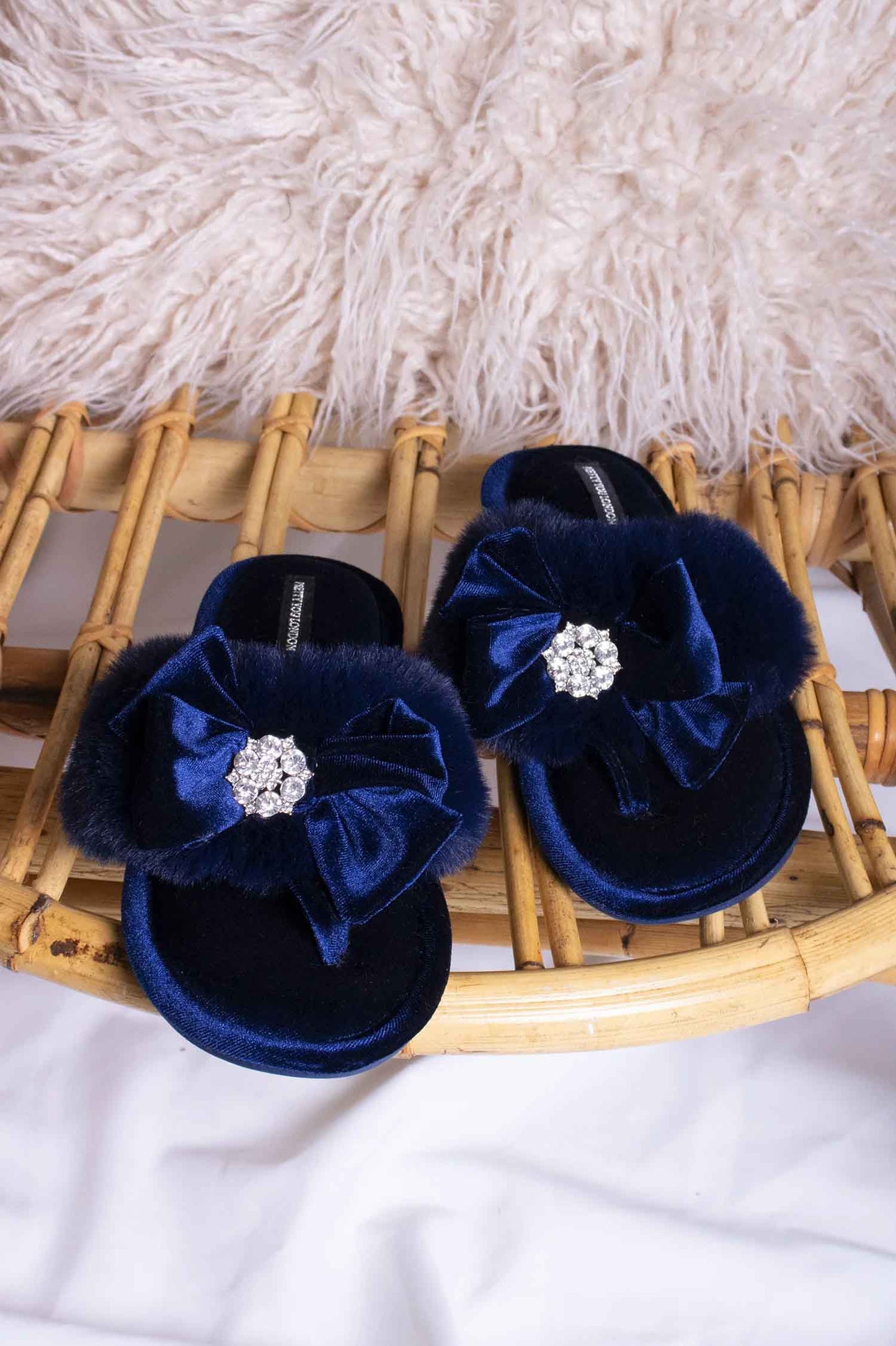 Amelie women's toe post slippers in navy with a premium velvet bow and diamante embellishment atop a plush faux fur band from Pretty You London