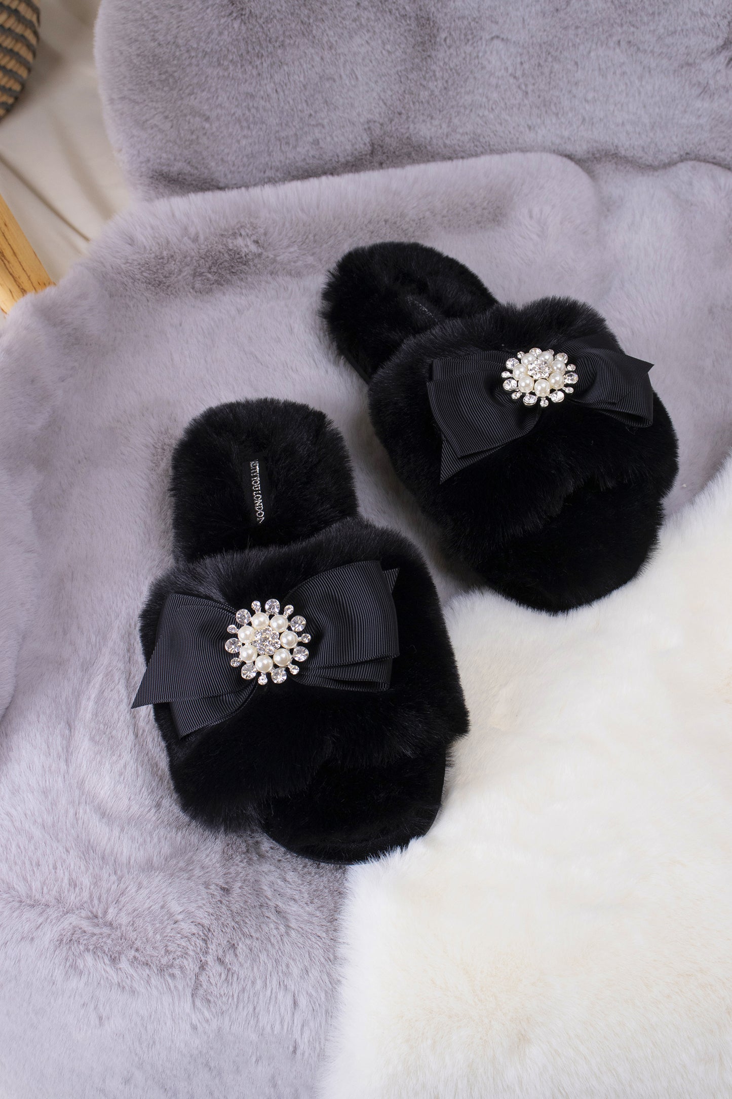 
                  
                    Anya women's slider slippers in black using the softest faux furs and topped with a premium grosgrain bow finished with a jewel pearl embellishment from Pretty You London
                  
                
