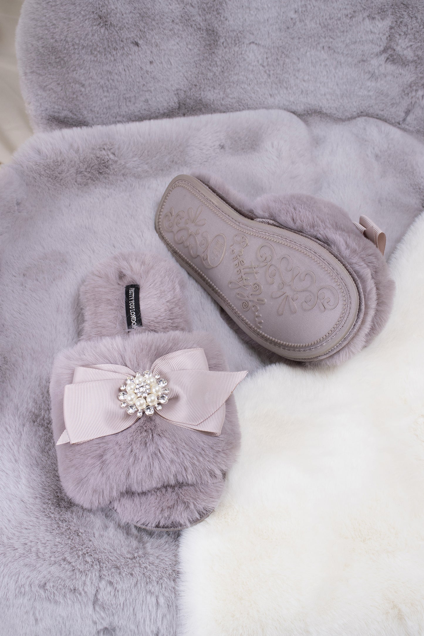 
                  
                    Anya women's slider slippers in mink using the softest faux furs and topped with a premium grosgrain bow finished with a jewel pearl embellishment from Pretty You London
                  
                
