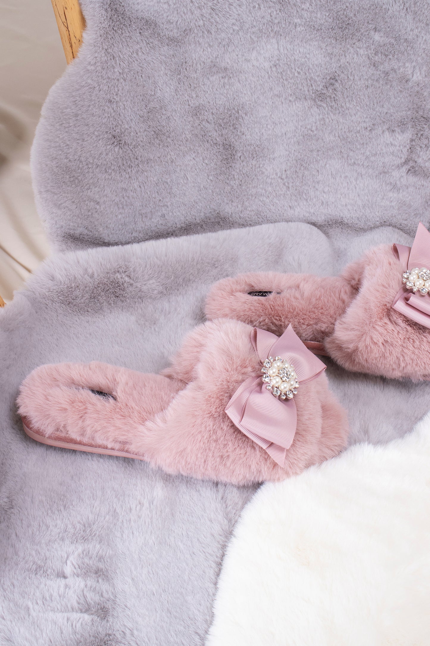
                  
                    Anya women's slider slippers in pink using the softest faux furs and topped with a premium grosgrain bow finished with a jewel pearl embellishment from Pretty You London
                  
                