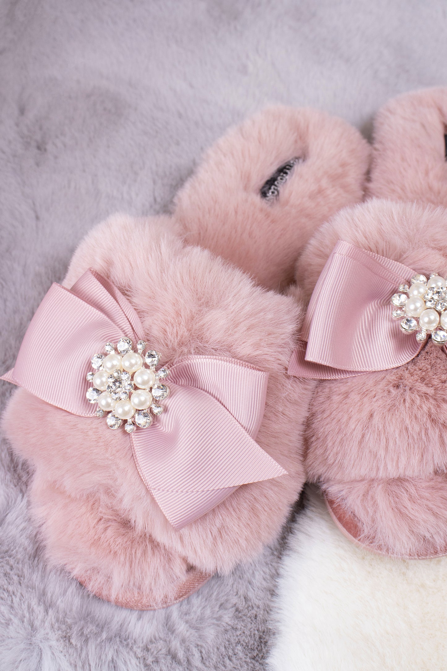 
                  
                    Anya women's slider slippers in pink using the softest faux furs and topped with a premium grosgrain bow finished with a jewel pearl embellishment from Pretty You London
                  
                