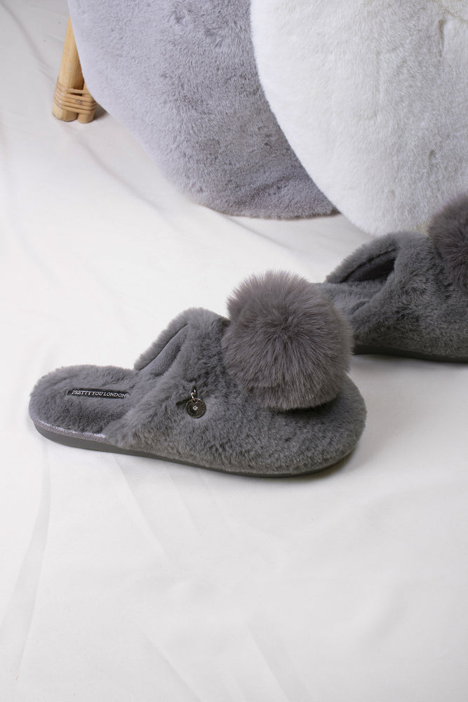 
                  
                    Etta women's mule slippers in grey with a statement oversized pom and metallic faux-suede binding from Pretty You London
                  
                